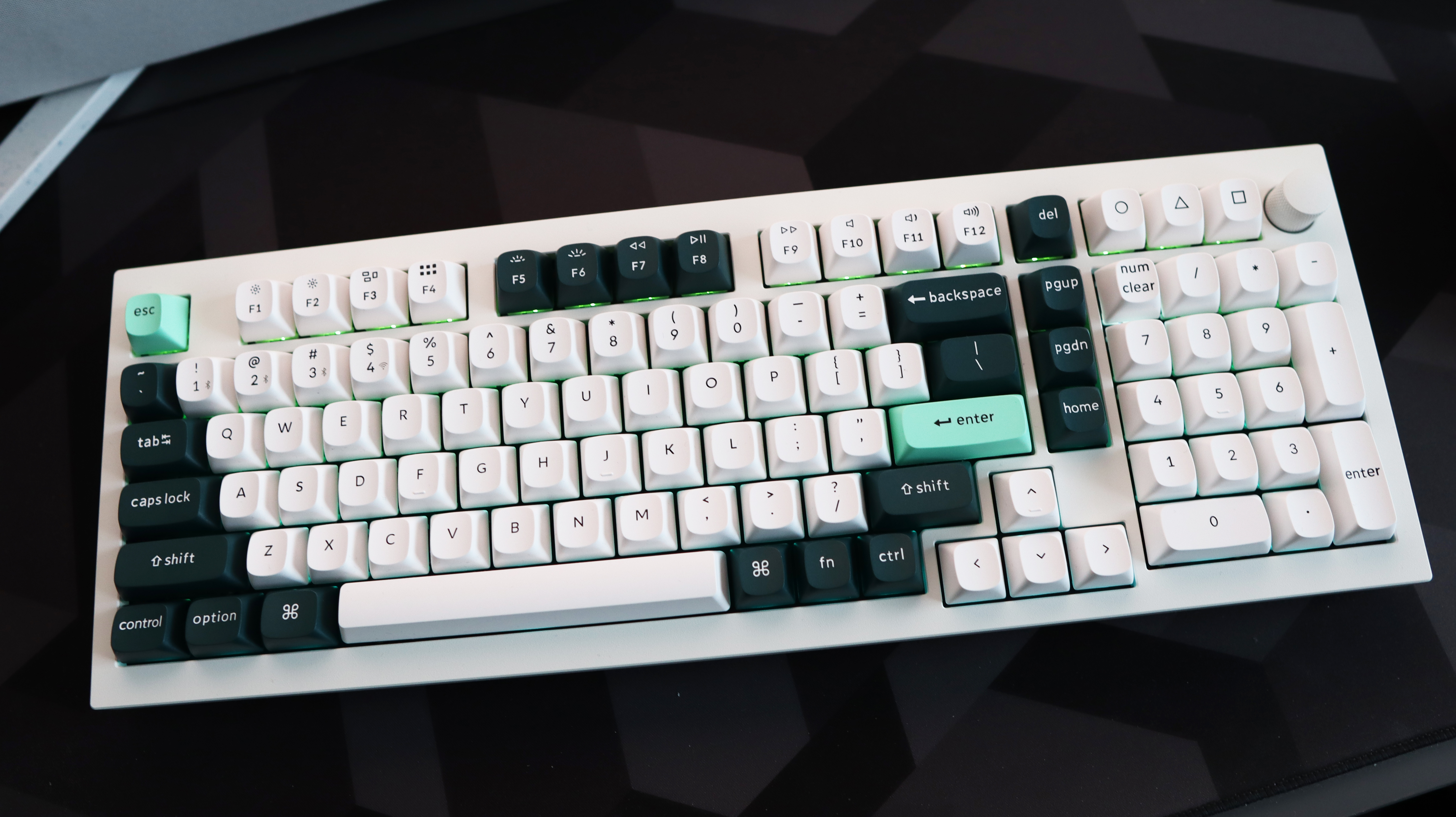 A Keychron Q5 HE gaming keyboard on a desk with white and blue keycaps.