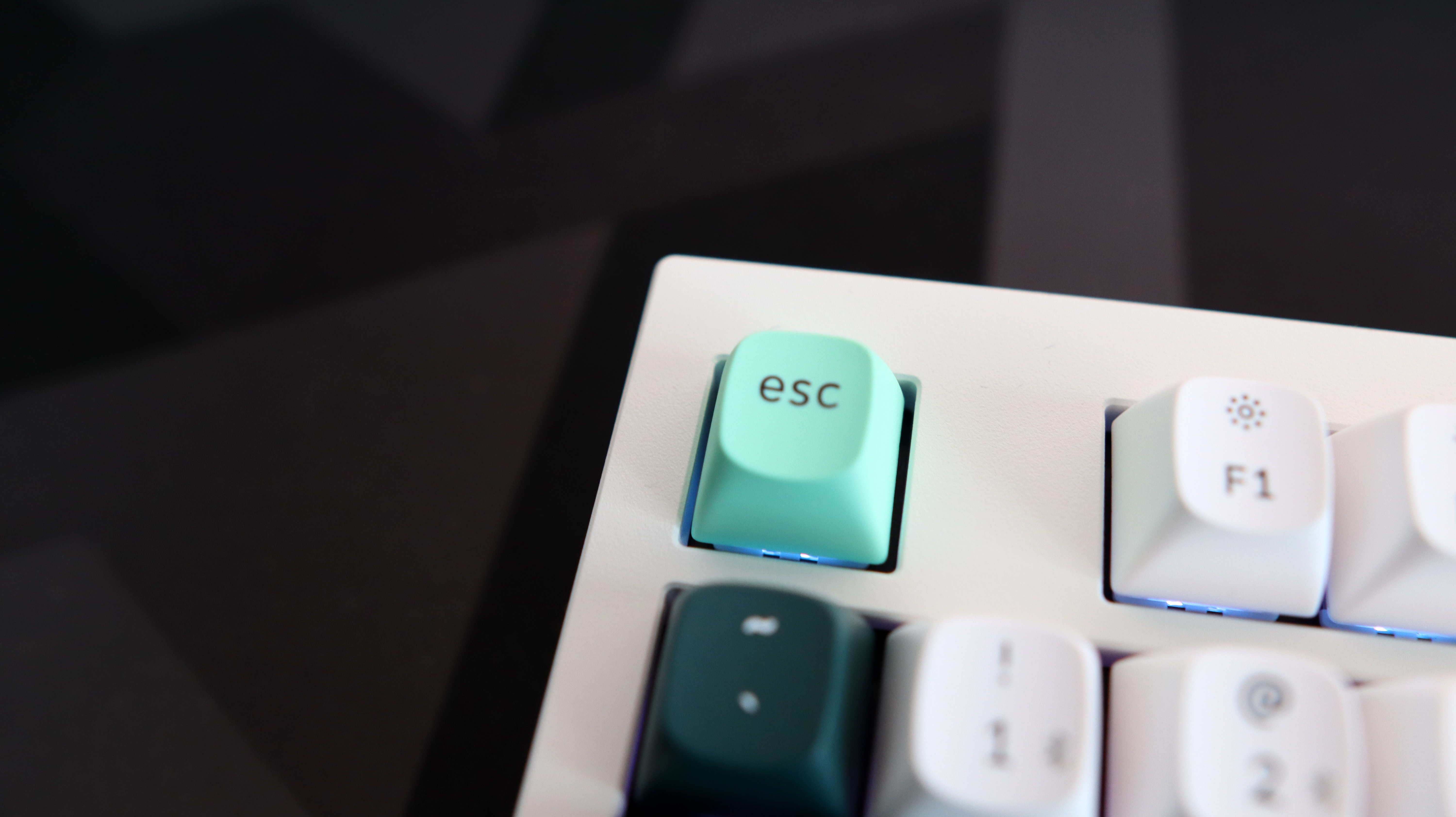 A Keychron Q5 HE gaming keyboard on a desk with white and blue keycaps.