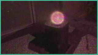 A glowing orb on top of a small table in a hazy room in The Moth Inside Me.