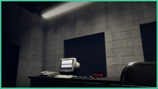 A PC monitor with static on the screen, with a phone to the left and a clock to the right which is displaying 12:22AM as the time in SUITBORN.