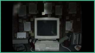 A retro desktop computer, with empty cans on the desk and various pieces of paper attached to the wall covered in notes in Tunnel Vision.