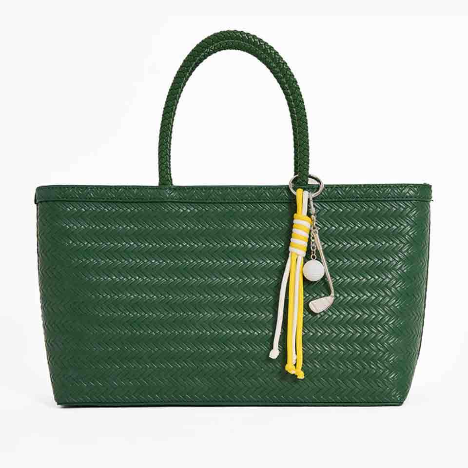 A green woven tote bag with a single handle, featuring a decorative keychain with yellow and white tassels and a white ball charm&mdash;perfect for stylish accessories or thoughtful Mother&rsquo;s Day gifts.