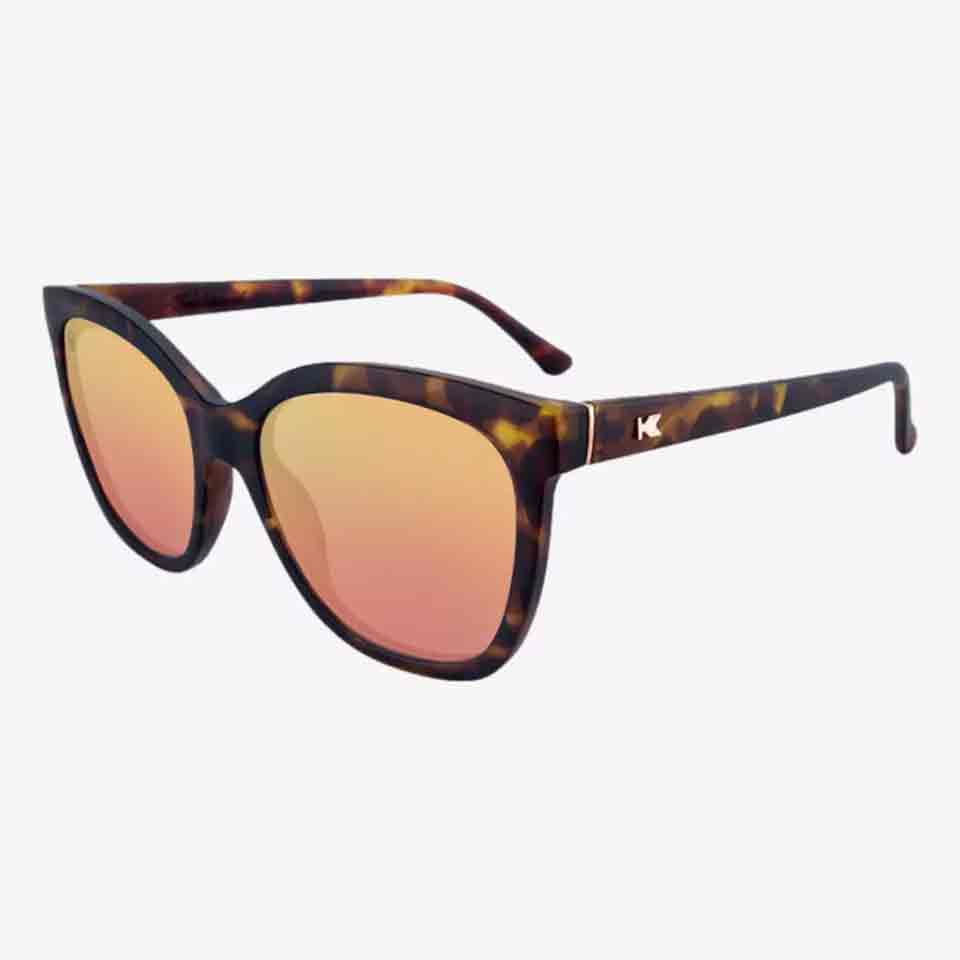 Tortoiseshell cat-eye sunglasses with pink mirrored lenses and a small metallic logo on the left temple, shown on a white background&mdash;perfect stylish accessories or thoughtful Mother&rsquo;s Day gifts.