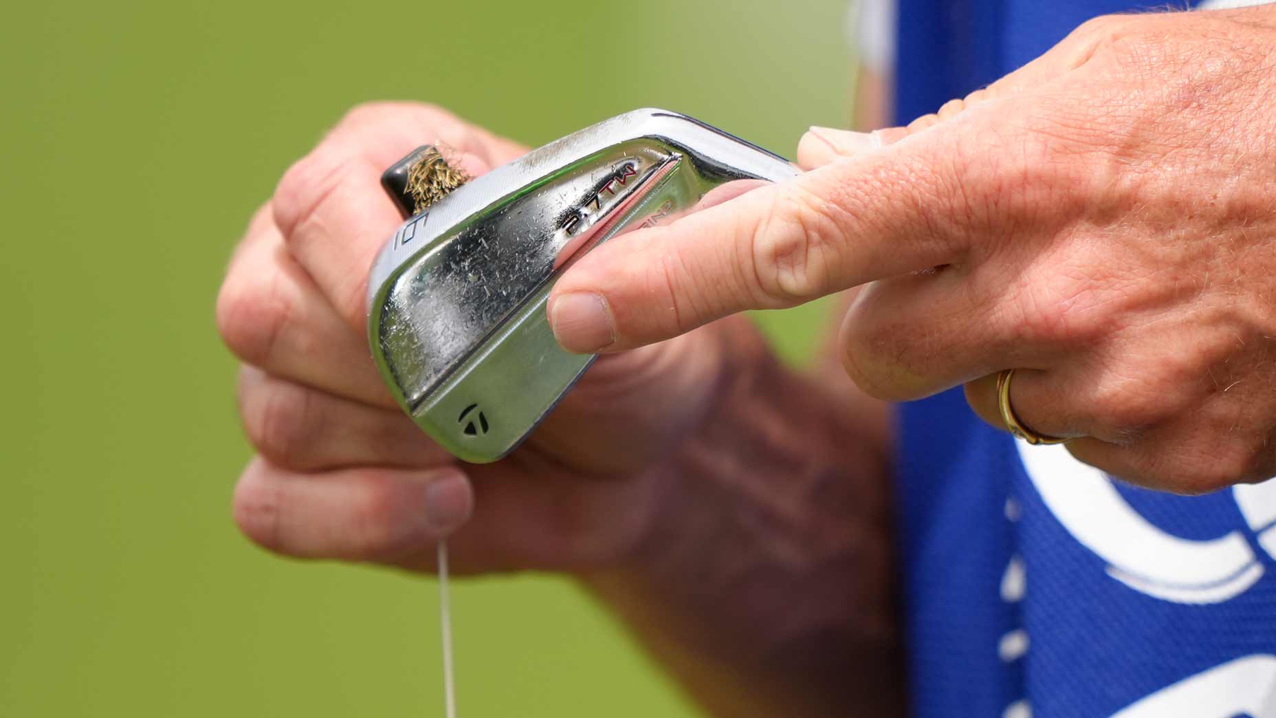 Ted Scott cleans Scottie Scheffler's irons.