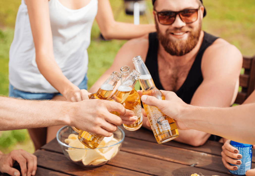 Happy young friends drinking beer and celebrating together