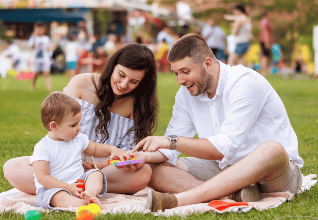 Young parents having fun on picnic with their child