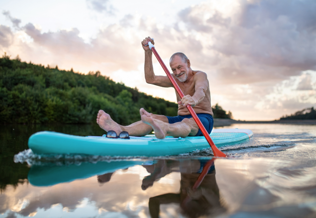Senior man paddleboarding on Lady Bird Lake in summer