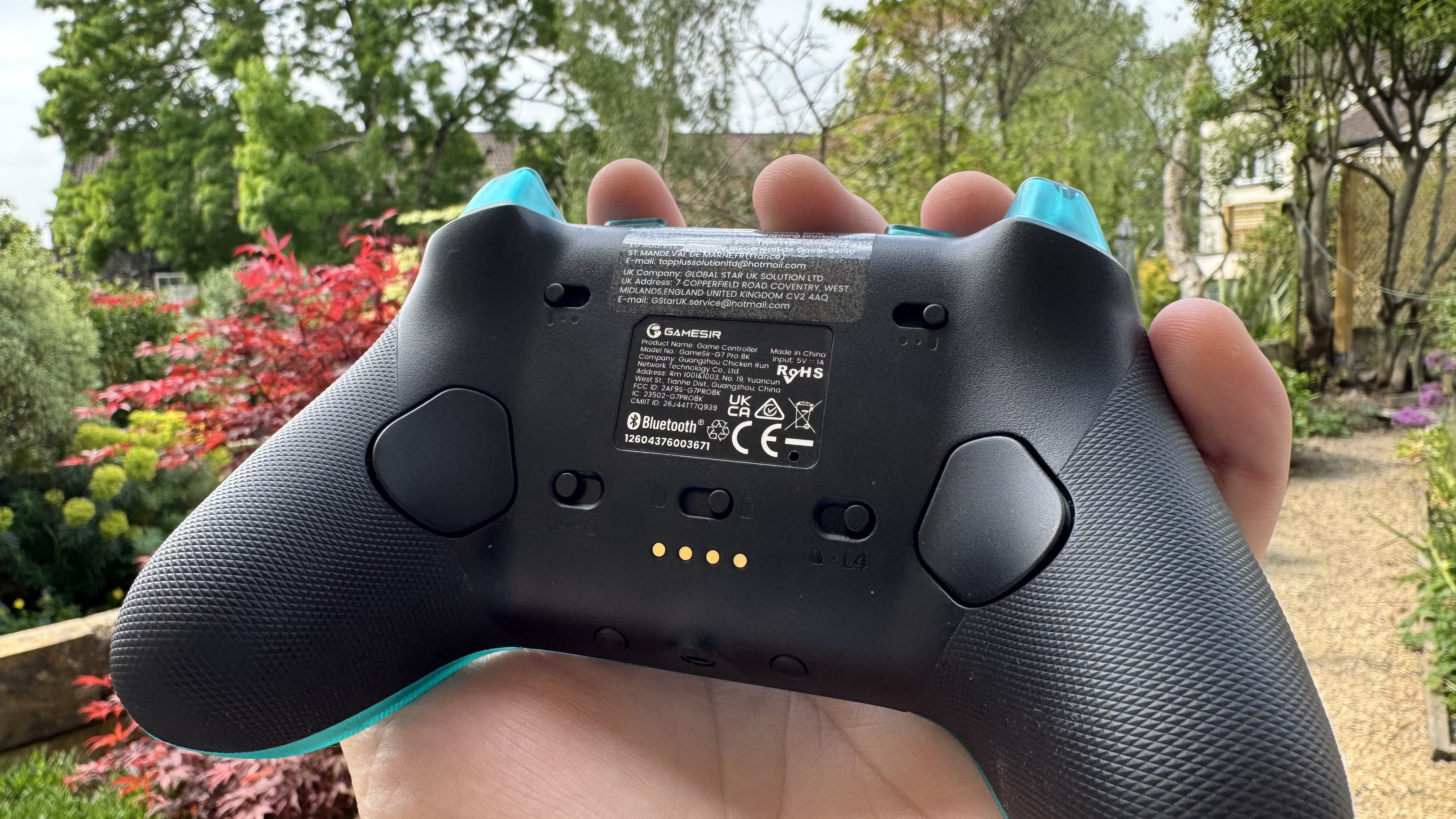 The GameSir G7 Pro 8K Aimlabs Edition from the back in a hand, outside