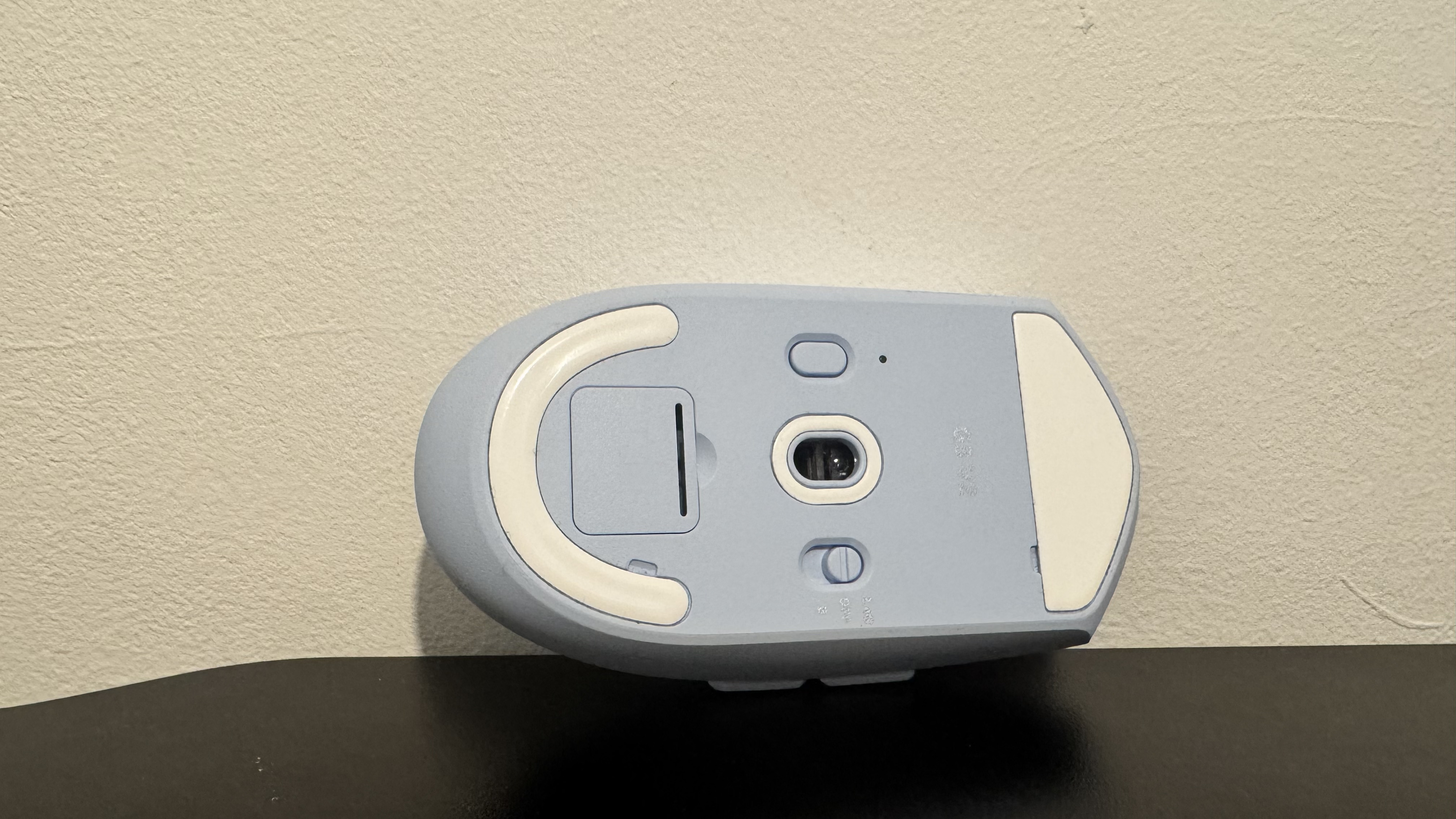 The blue Mchose G3 V2 gaming mouse from the bottom on a black desk