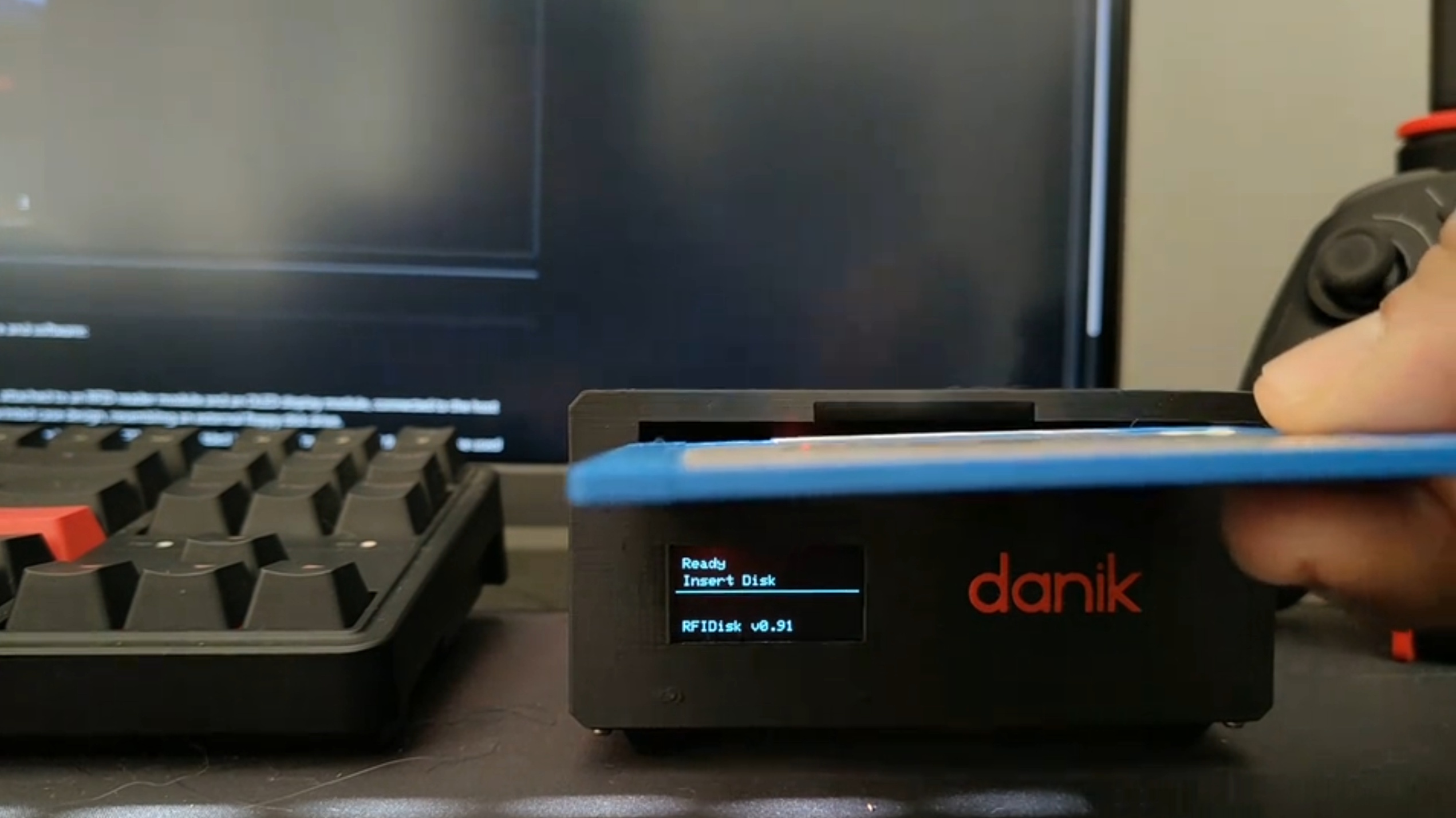 A hand putting a floppy disk into an RFIDisk device.