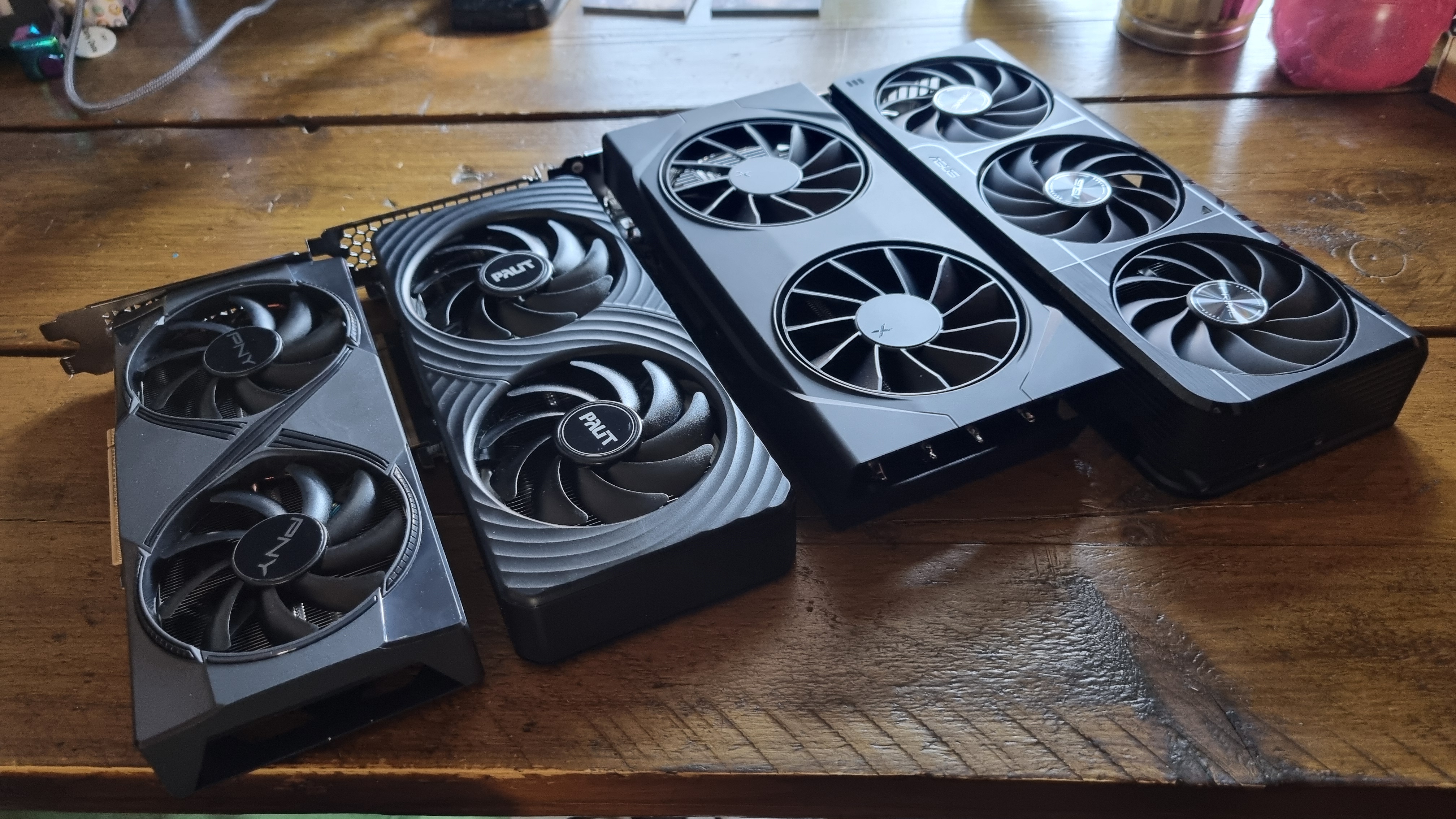 Four budget graphics cards lined up in a row on a wooden desk