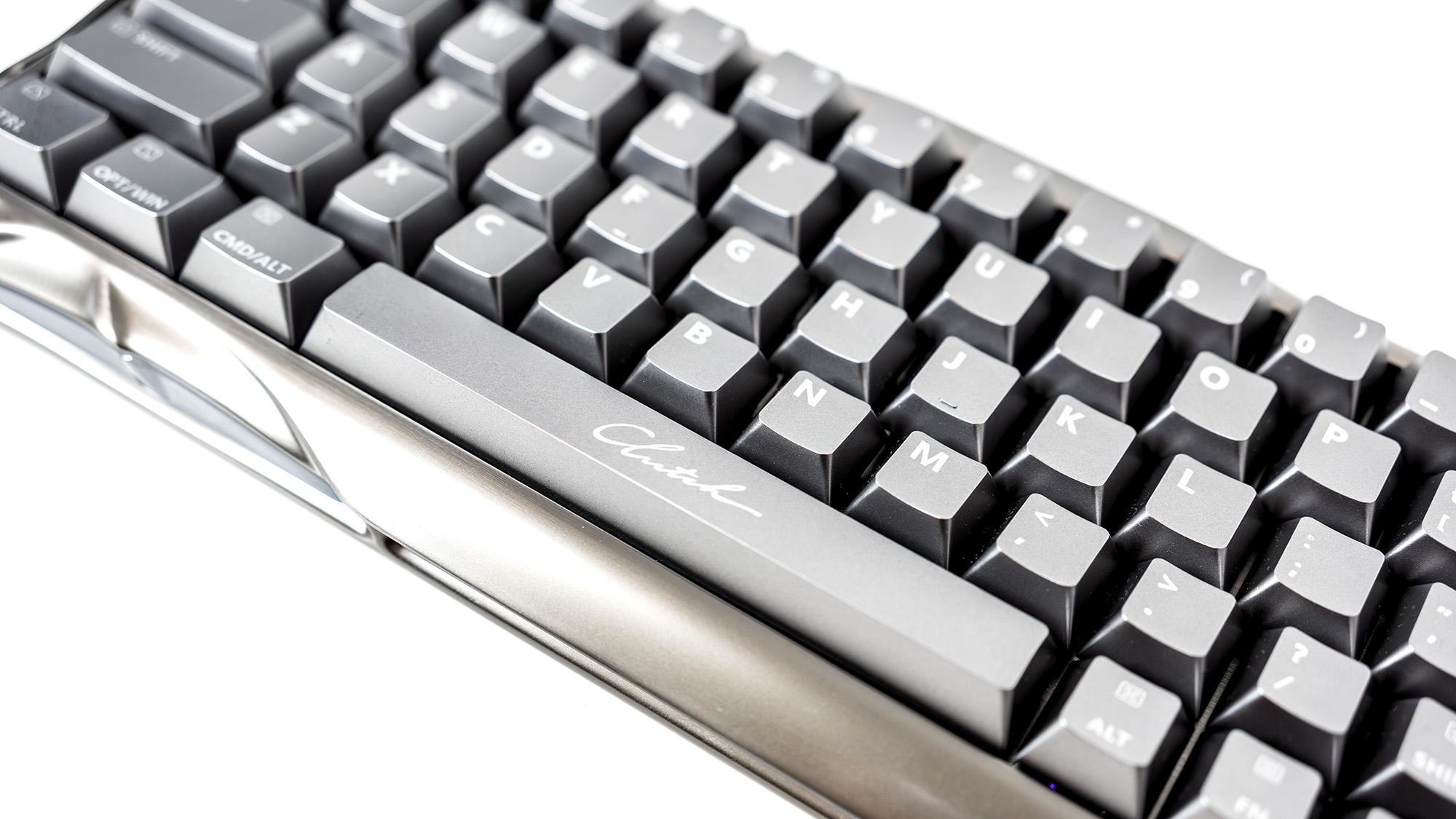 A Gravastar Mercury V60 Pro gaming keyboard with a shiny aluminium shell on a white desk.