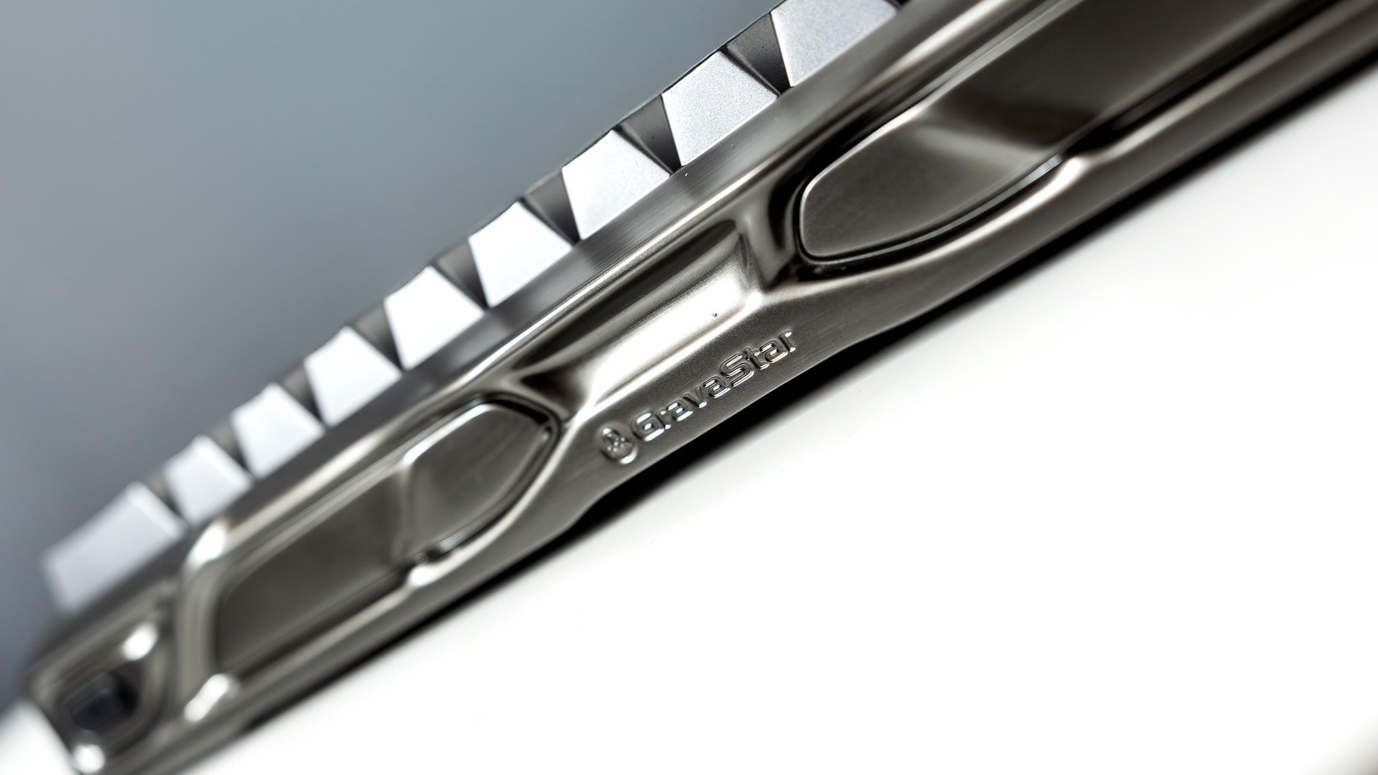 A Gravastar Mercury V60 Pro gaming keyboard with a shiny aluminium shell on a white desk.