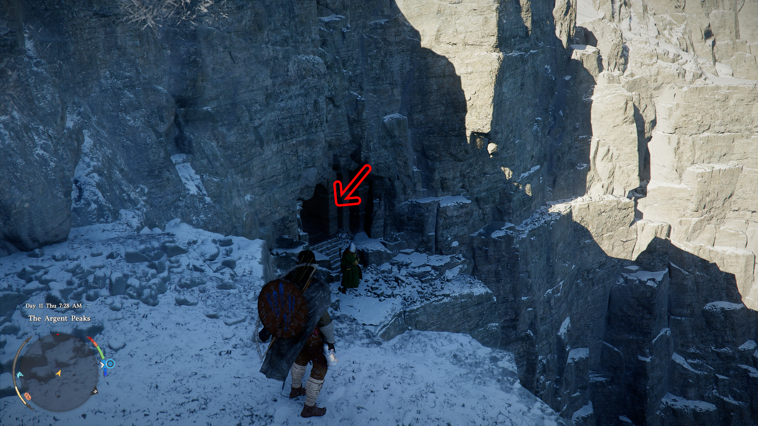 Crimson Desert Soul Spear: Kliff standing next to a ledge overlooking a cave entrance in a snowy cliff side, with a red arrow pointing inside.