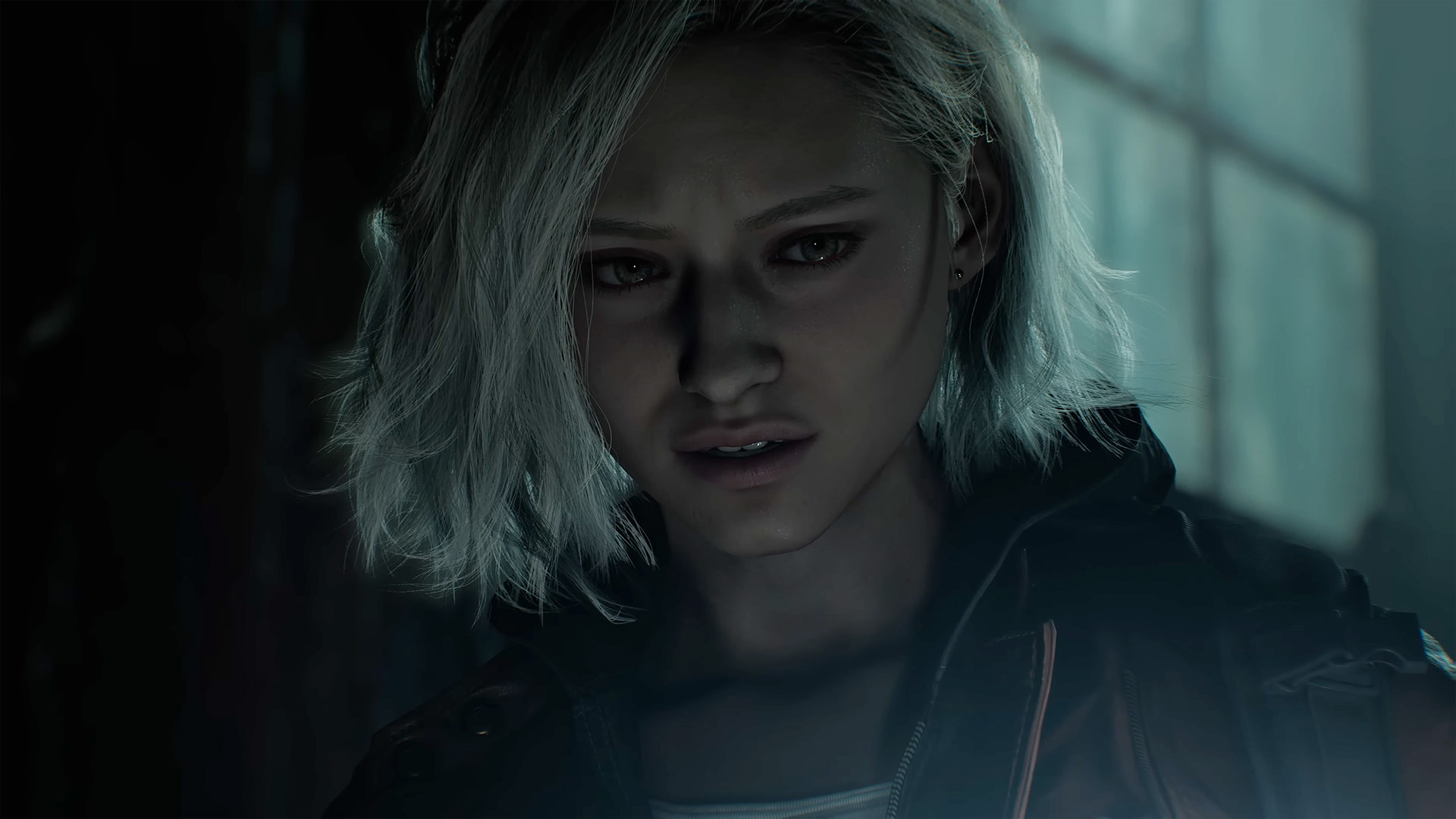 A woman from Resident Evil Requiem with short platinum-colored hair standing in the dark. The shot is close up on her face and she looks frightened.