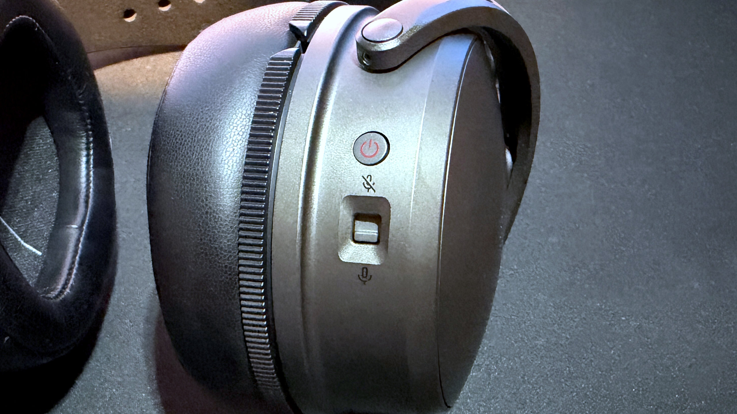 A photo of the Audeze Maxwell 2 wireless gaming headset, focused on the power and mute switch