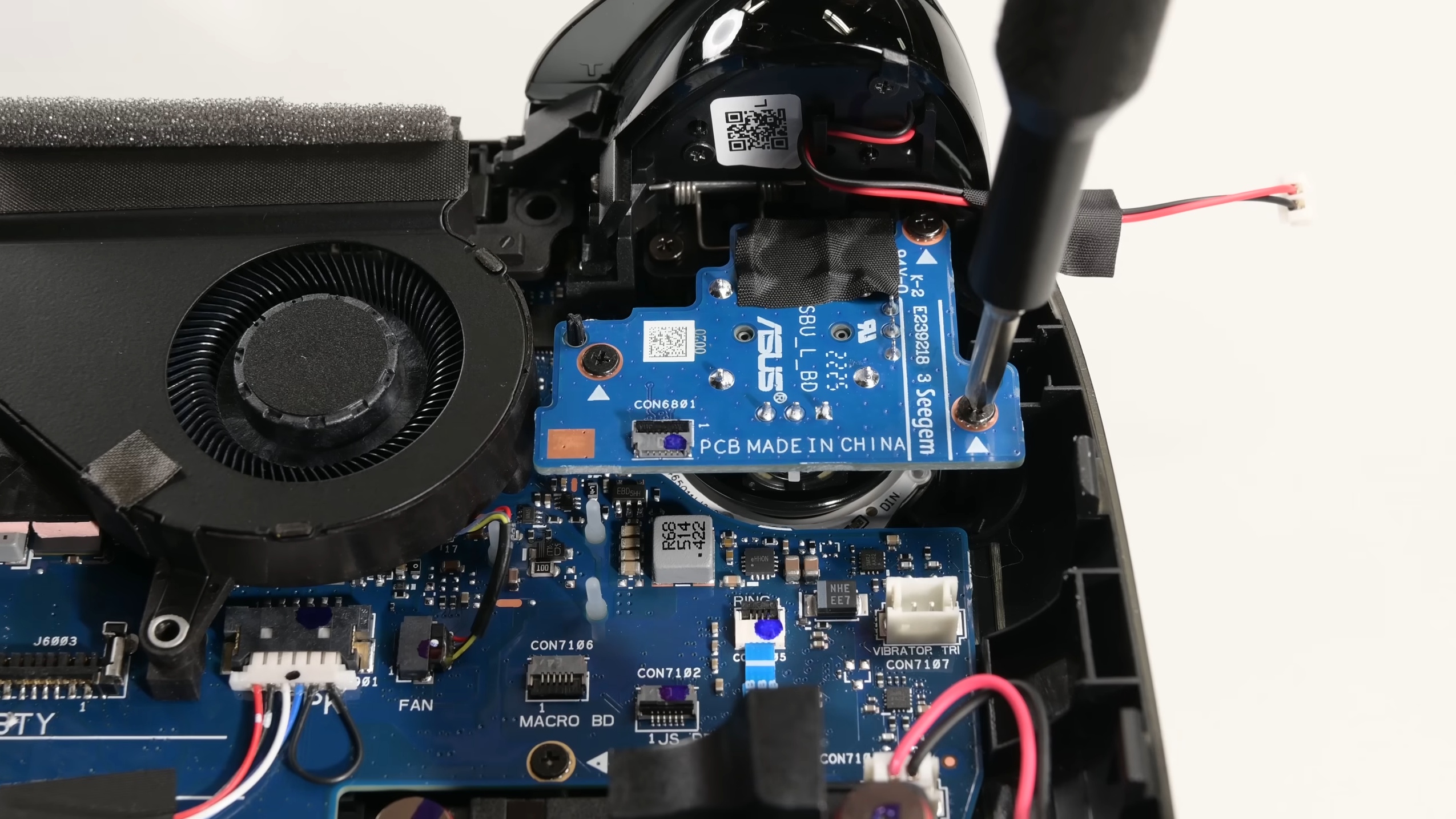 iFixit showing inside a disassembled Asus ROG Xbox Ally X, unscrewing one of the thumbstick modules