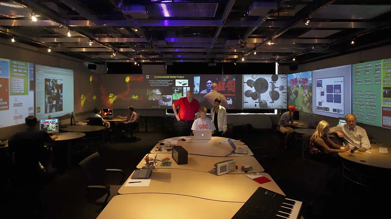 Students learn game design surrounded by screens