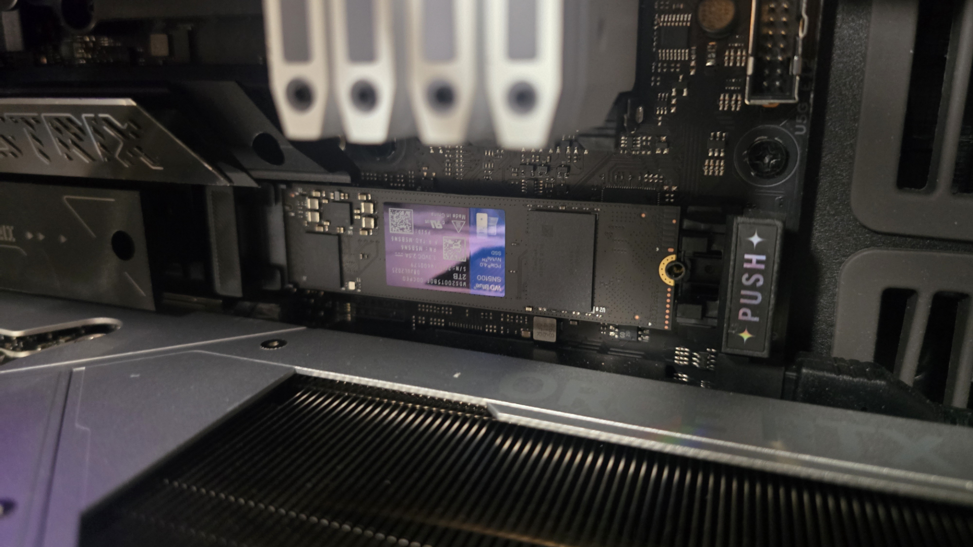 A WD Blue SN5100 ready to be installed inside a gaming PC.