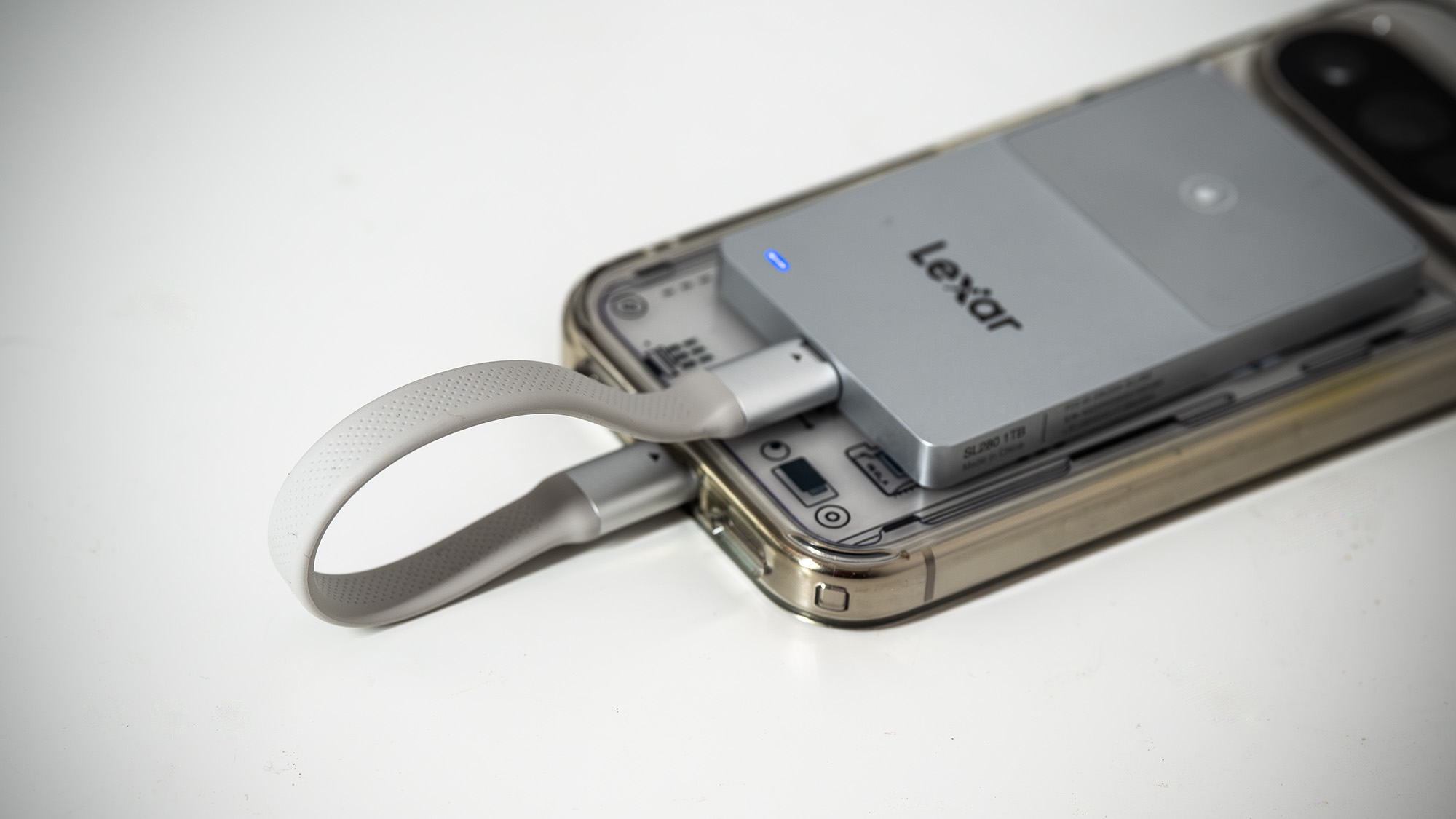 Lexar TouchLock Portable SSD on a white table with a phone.