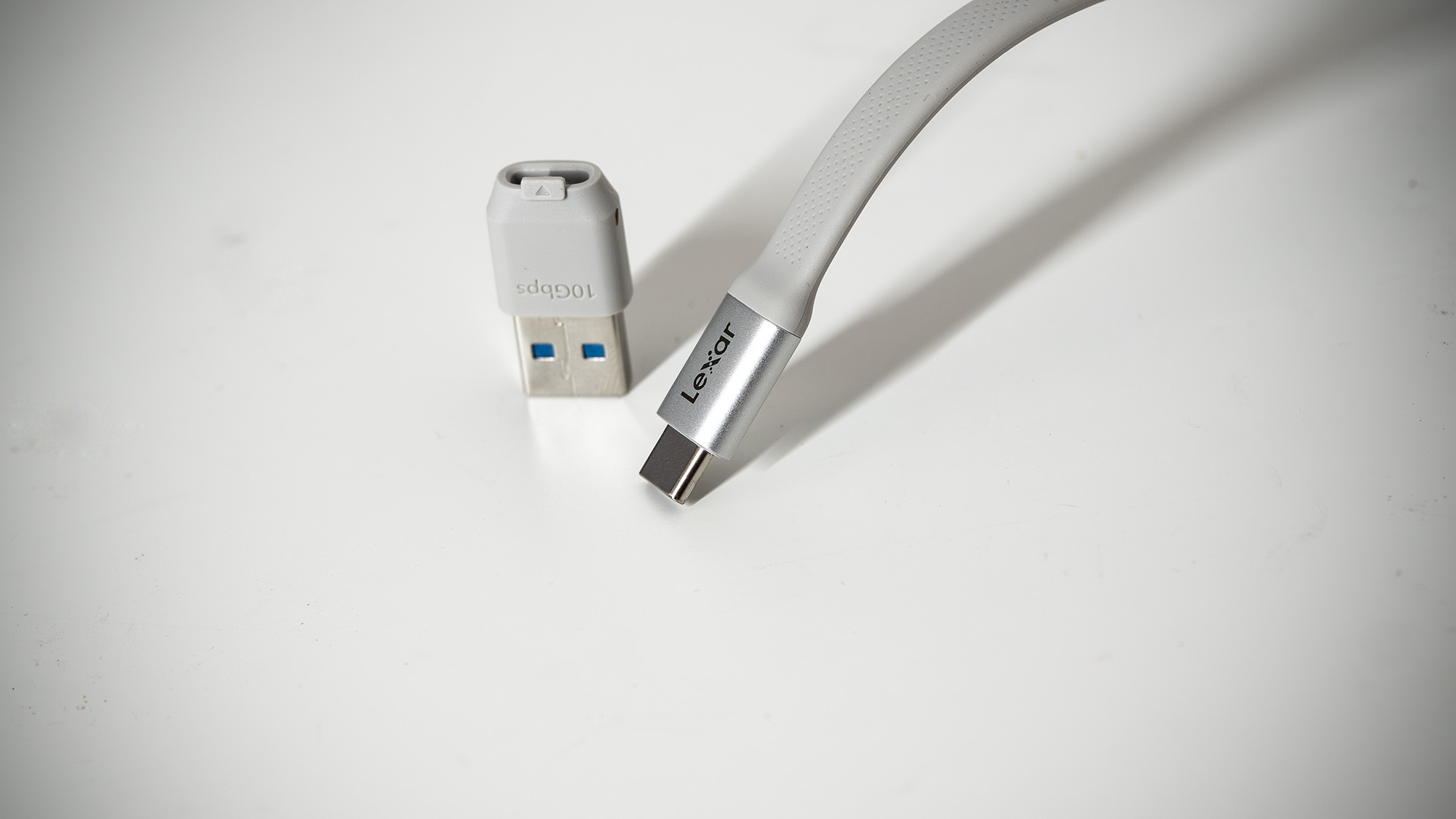 Lexar TouchLock Portable SSD on a white table with a phone.