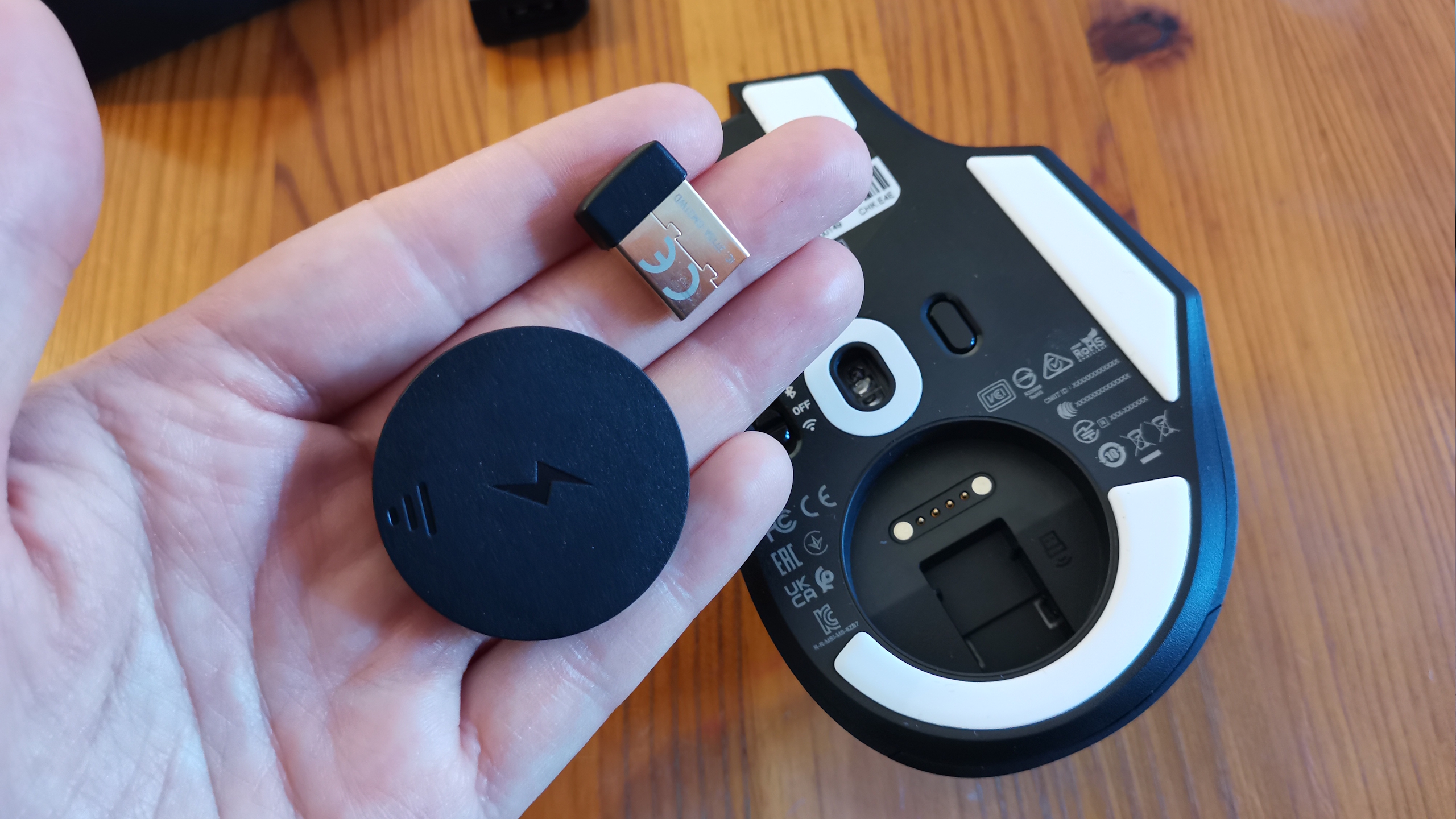 An MSI Versa Pro mouse on a desk with a charging dock and accessories.