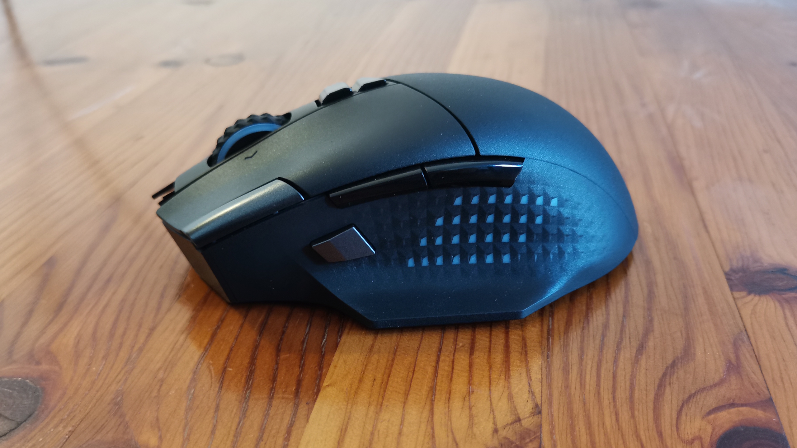 An MSI Versa Pro mouse on a desk with a charging dock and accessories.