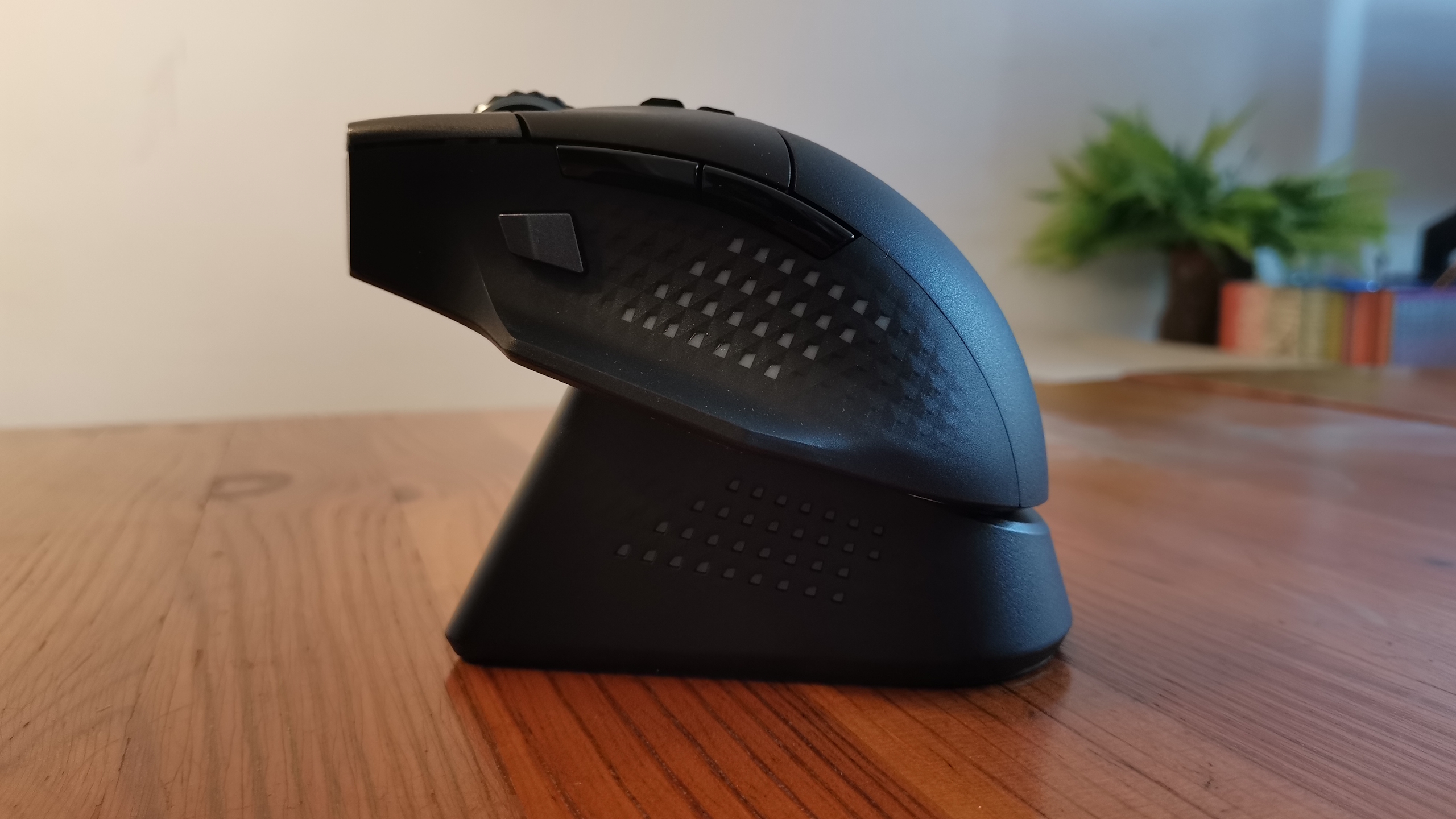 An MSI Versa Pro mouse on a desk with a charging dock and accessories.