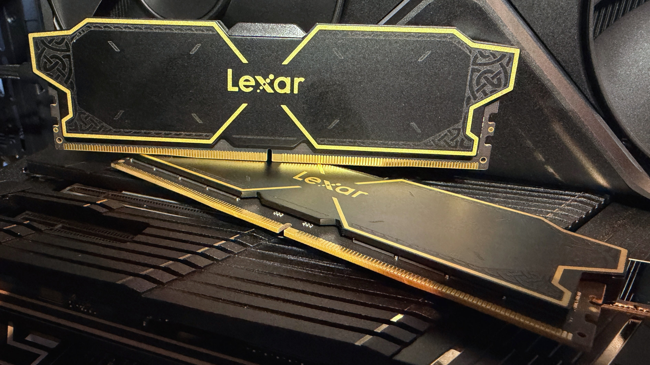 A photo of a set of Lexar Thor OC DDR5 UDIMMs, resting on top of a motherboard's heatsink