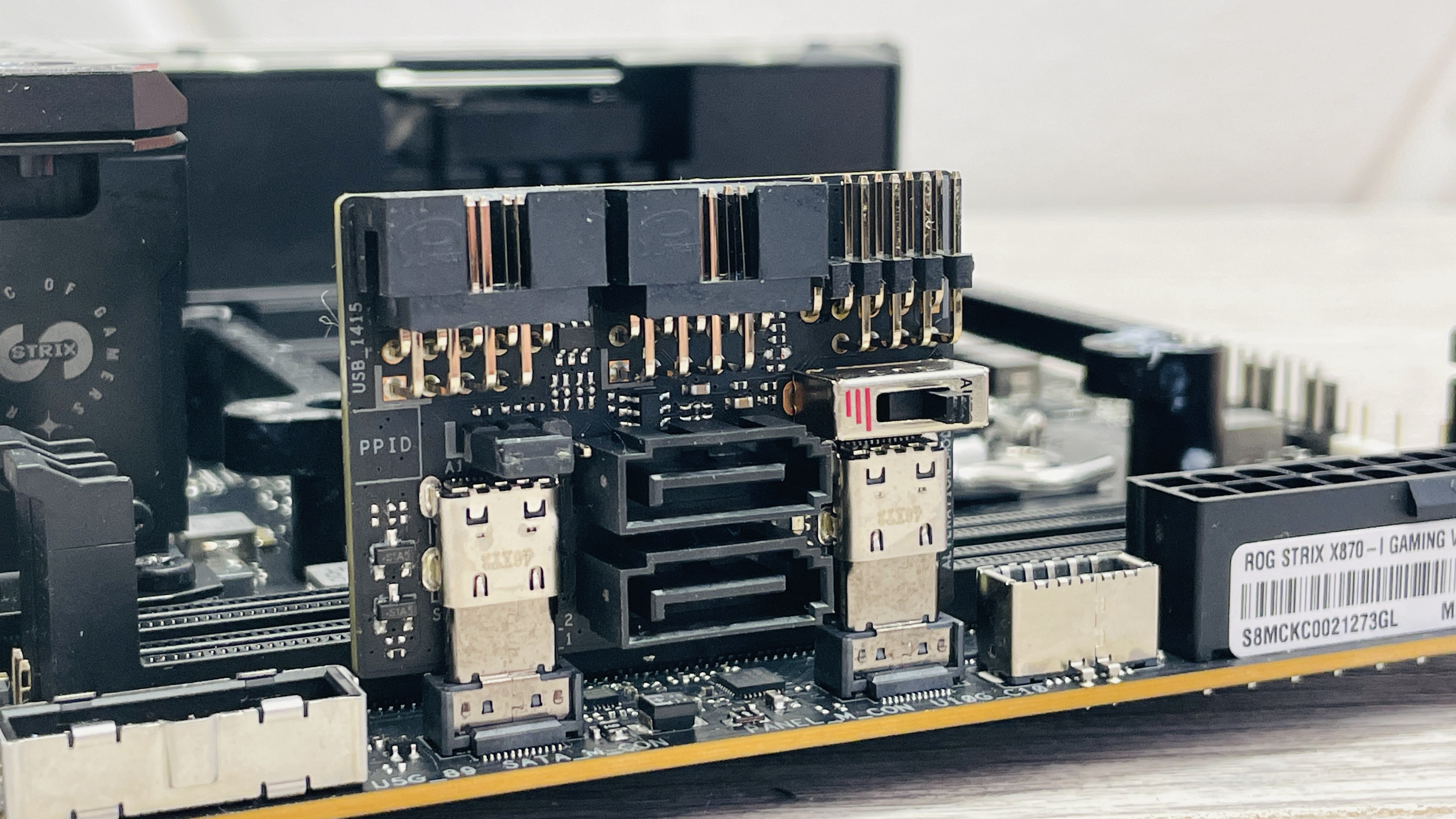 Asus ROG Strix X870-I Gaming WiFi motherboard on a desk.