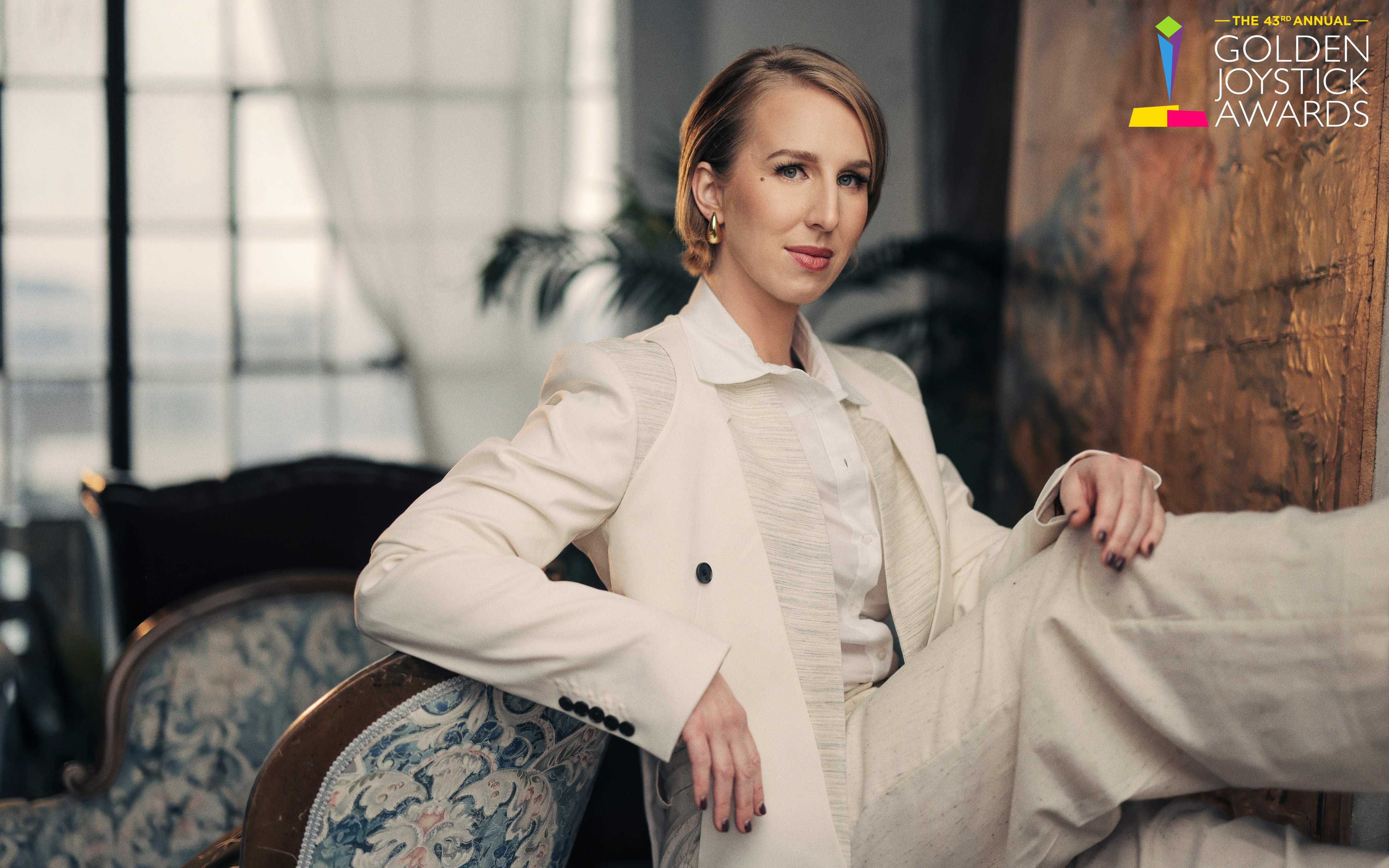 Maggie Robertson poses in a white suit.