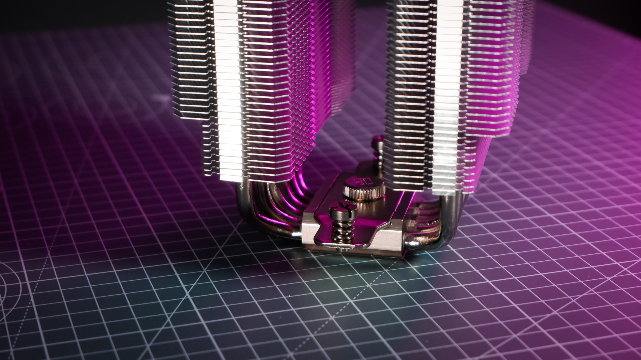 A Thermalright Peerless Assassin 120 SE cooler on a desk with the fans beside it.