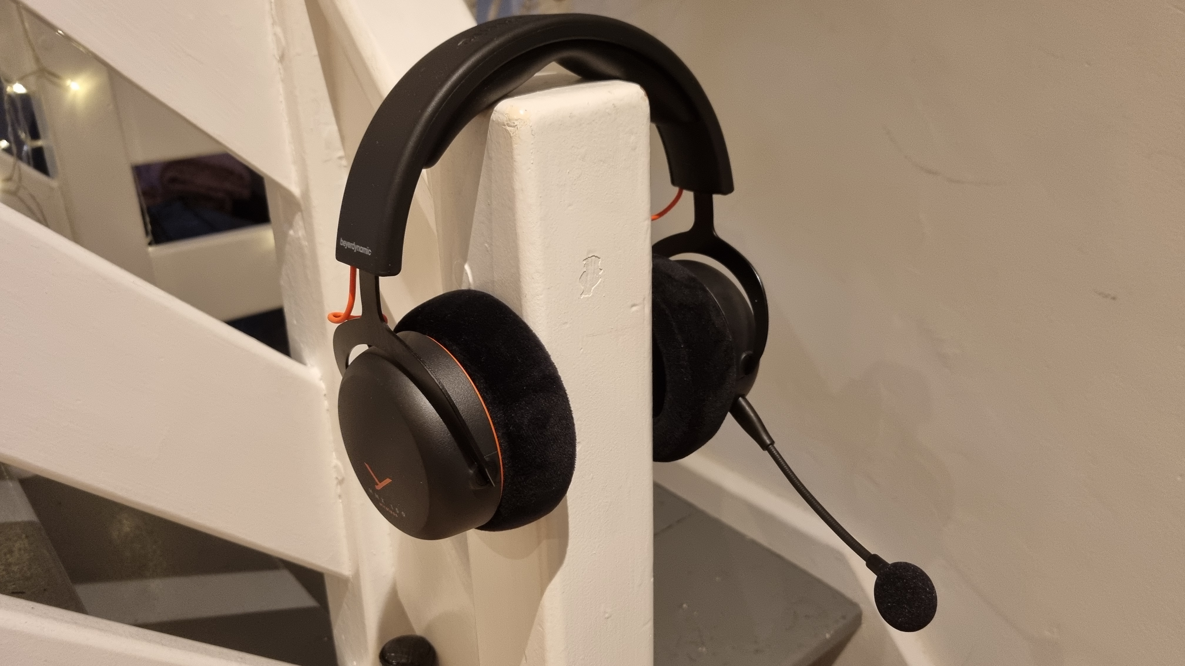 A Beyerdynamic MMX 150 Wireless gaming headset over a banister, as if being worn on the head