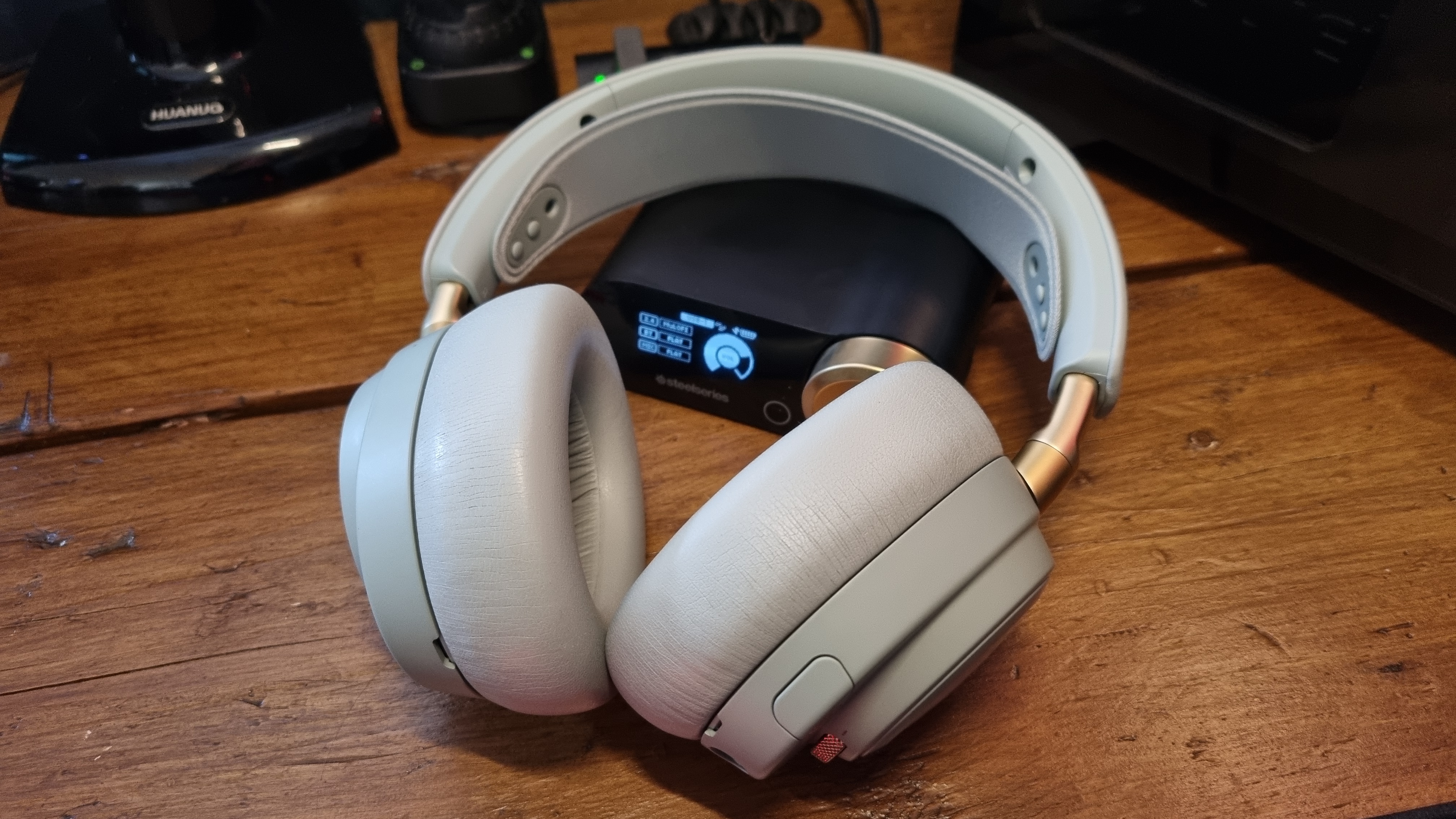 The SteelSeries Arctis Nova Elite gaming headset on a wooden desk, in