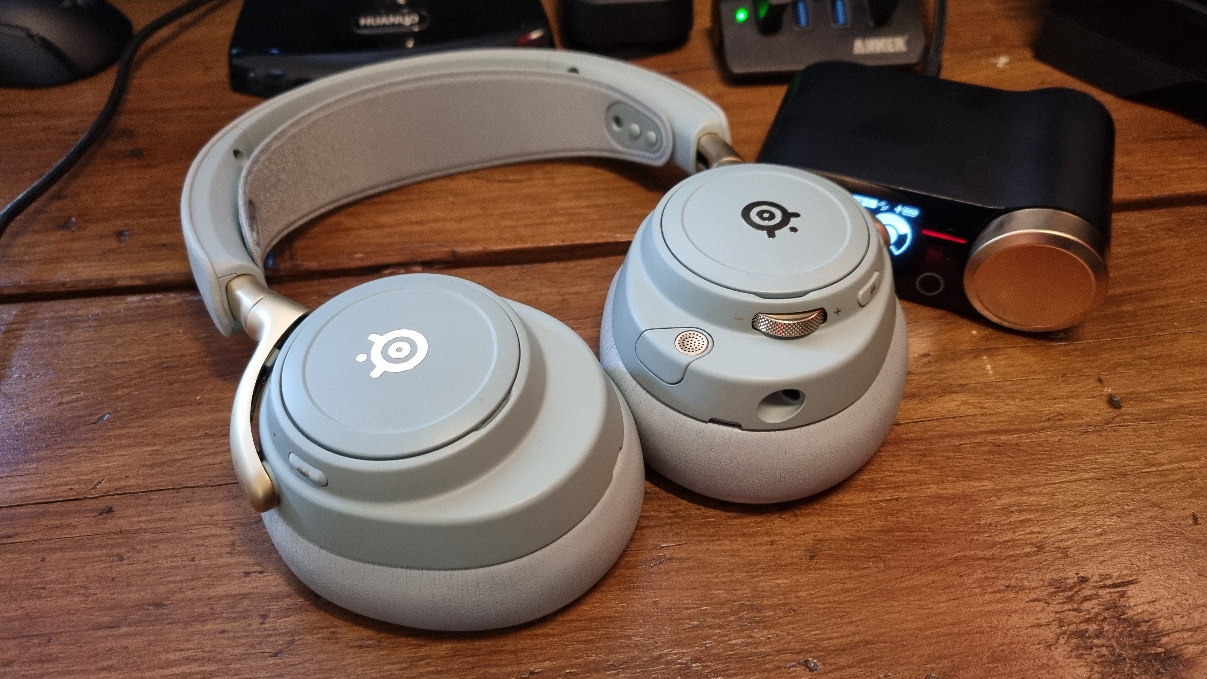 The SteelSeries Arctis Nova Elite gaming headset on a wooden desk, in