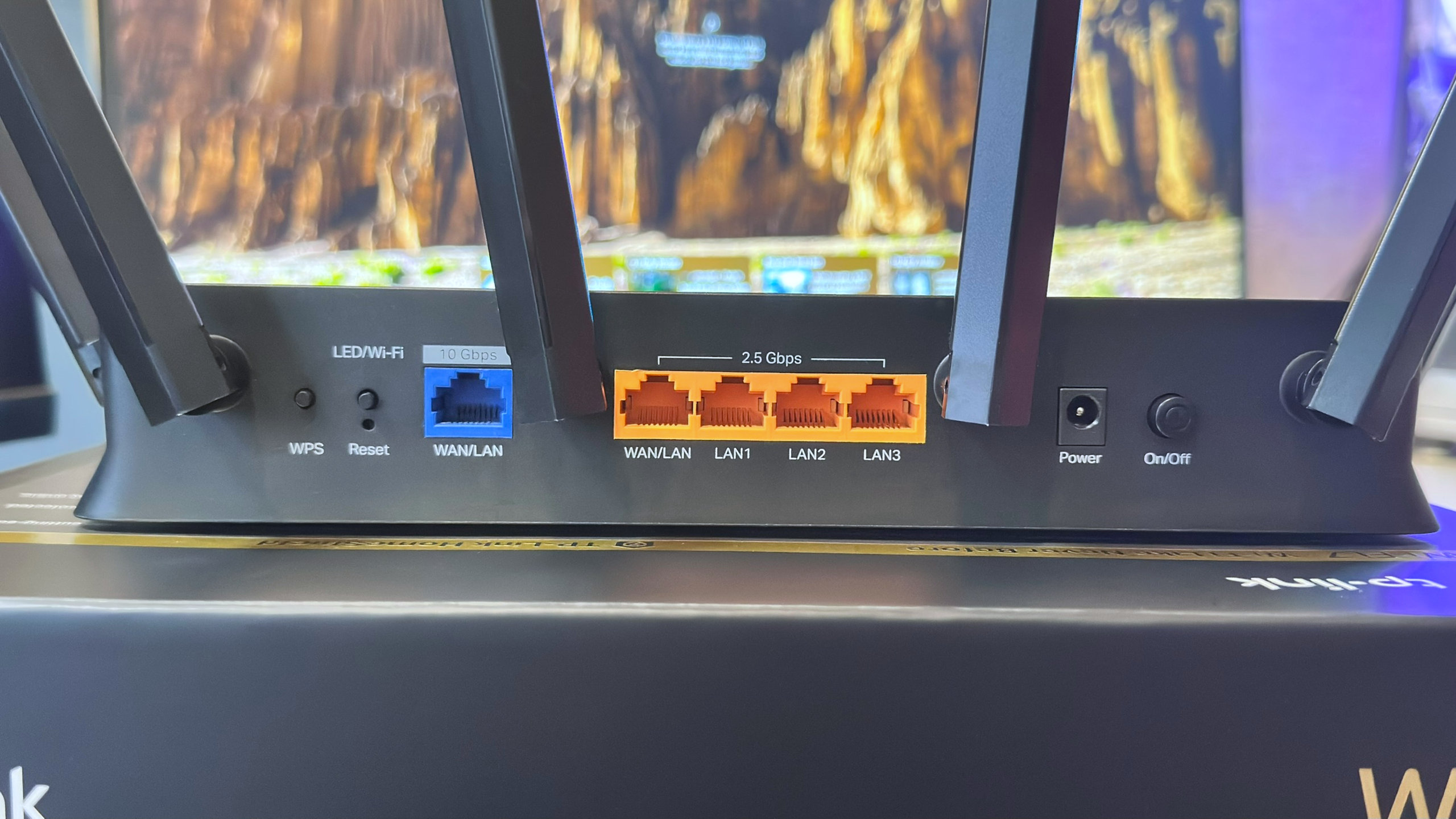 A photo of a TP-Link Archer BE9700 Wi-Fi 7 router, showing the WAN/LAN ports on the rear panel.