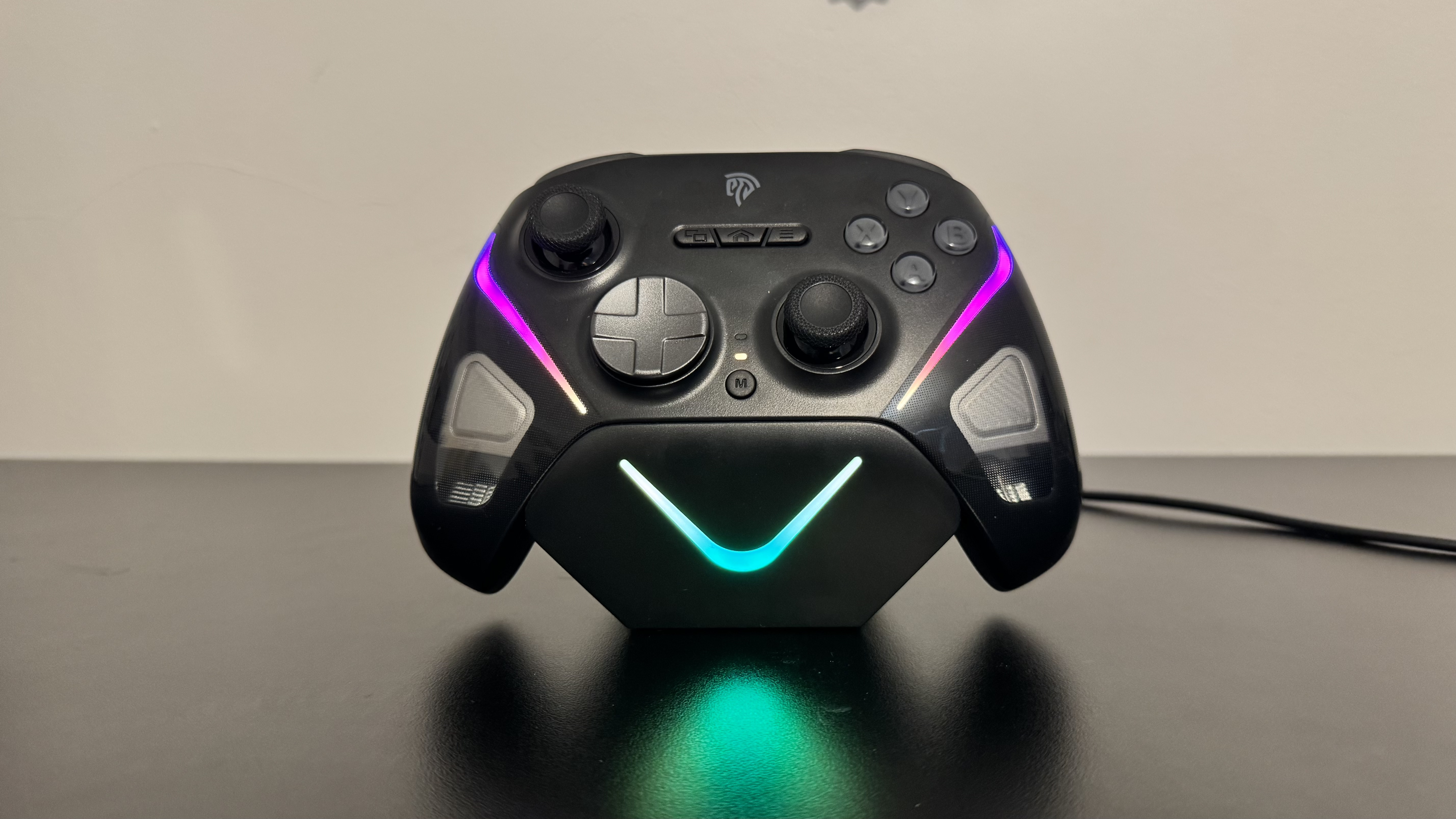 EasySMX D10 (on) on the charging stand on a black desk