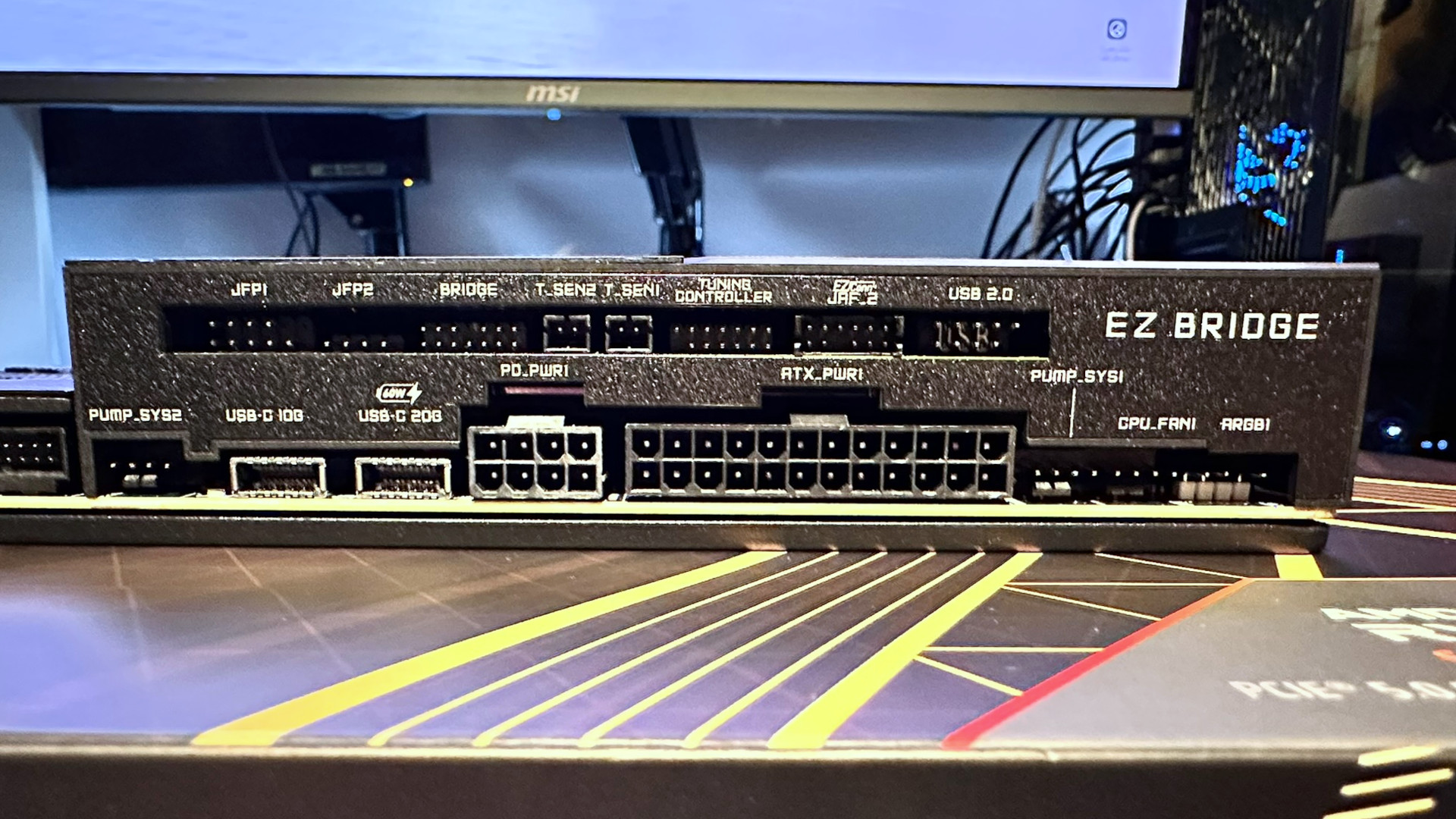 A photo showing some of the the various connector options on an MSI MEG X870E Godlike X Edition motherboard, underneath MSI's EZ Bridge system