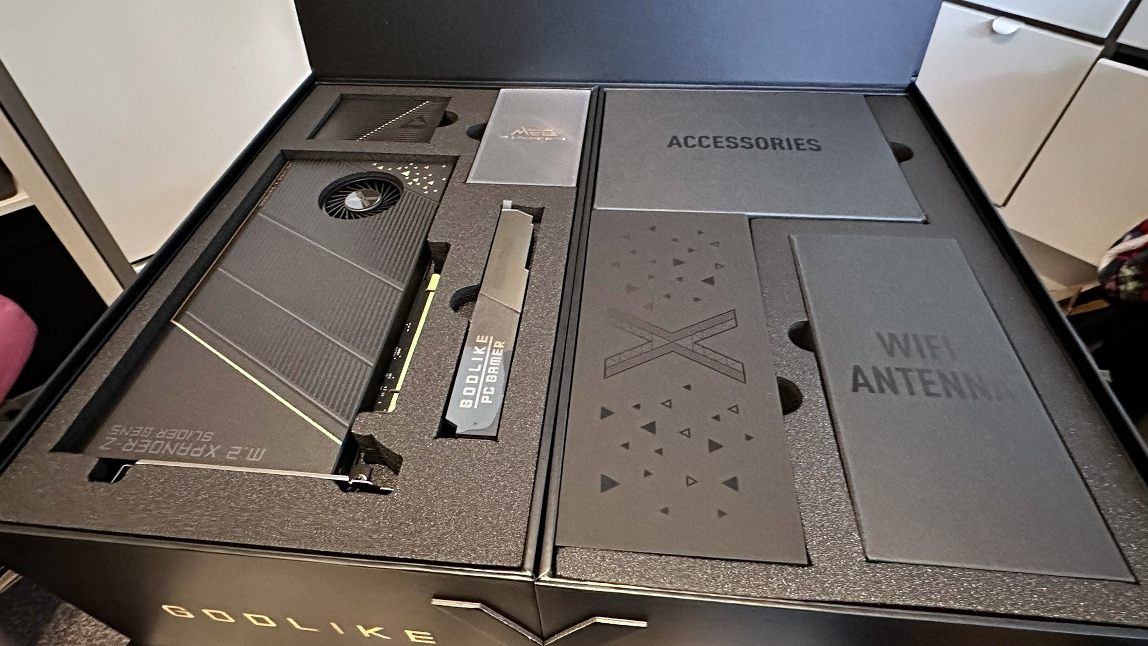 A photo showing the top layer of the retail box for an MSI MEG X870E Godlike X Edition motherboard