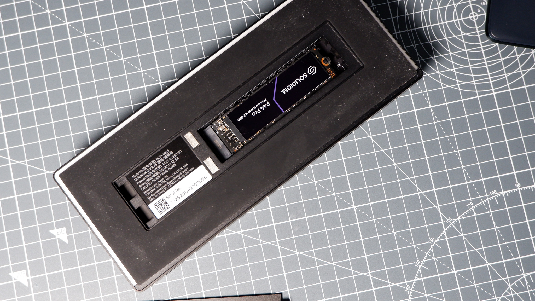 The Razer Thunderbolt 5 Dock on a desk with the RGB enabled and an SSD installed.