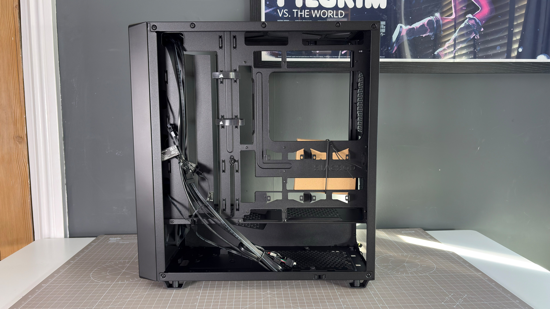 A Corsair PC case, the 3200D, on a desk with various panels removed and ready for a PC build.
