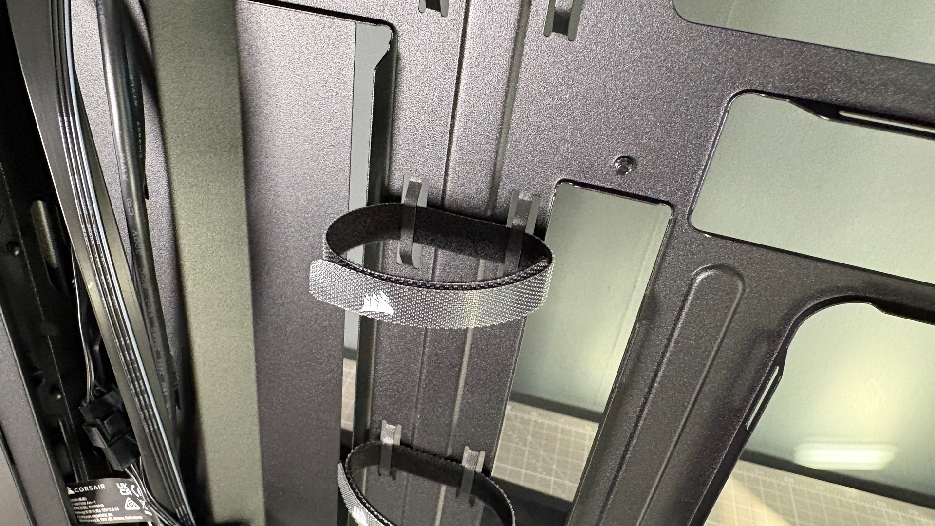 A Corsair PC case, the 3200D, on a desk with various panels removed and ready for a PC build.